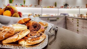 Un buffet proposant des pâtisseries, des fruits et des boissons.