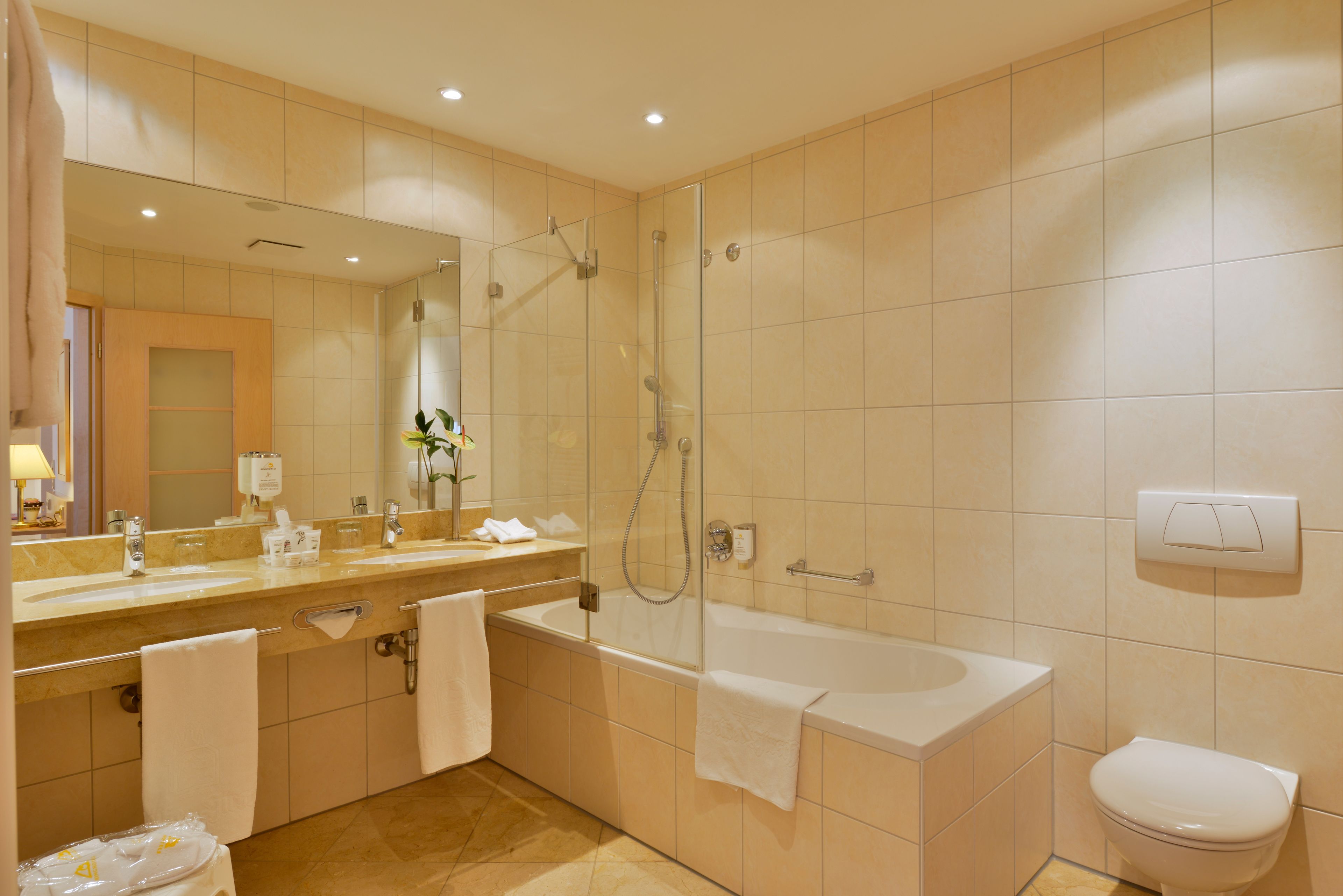 A modern bathroom with a bathtub, shower, and sink.