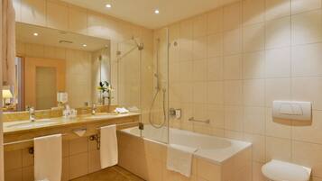 A modern bathroom with a bathtub, shower, and sink.
