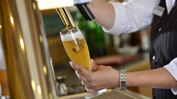 Una persona sirviendo cerveza en un vaso.