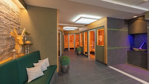 A modern lobby with a green sofa, a wooden deer head sculpture, and a reception desk.