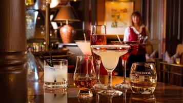 En bar med ett urval av olika sorters drycker i glas, inklusive en flaska Glenmorangie-whisky.