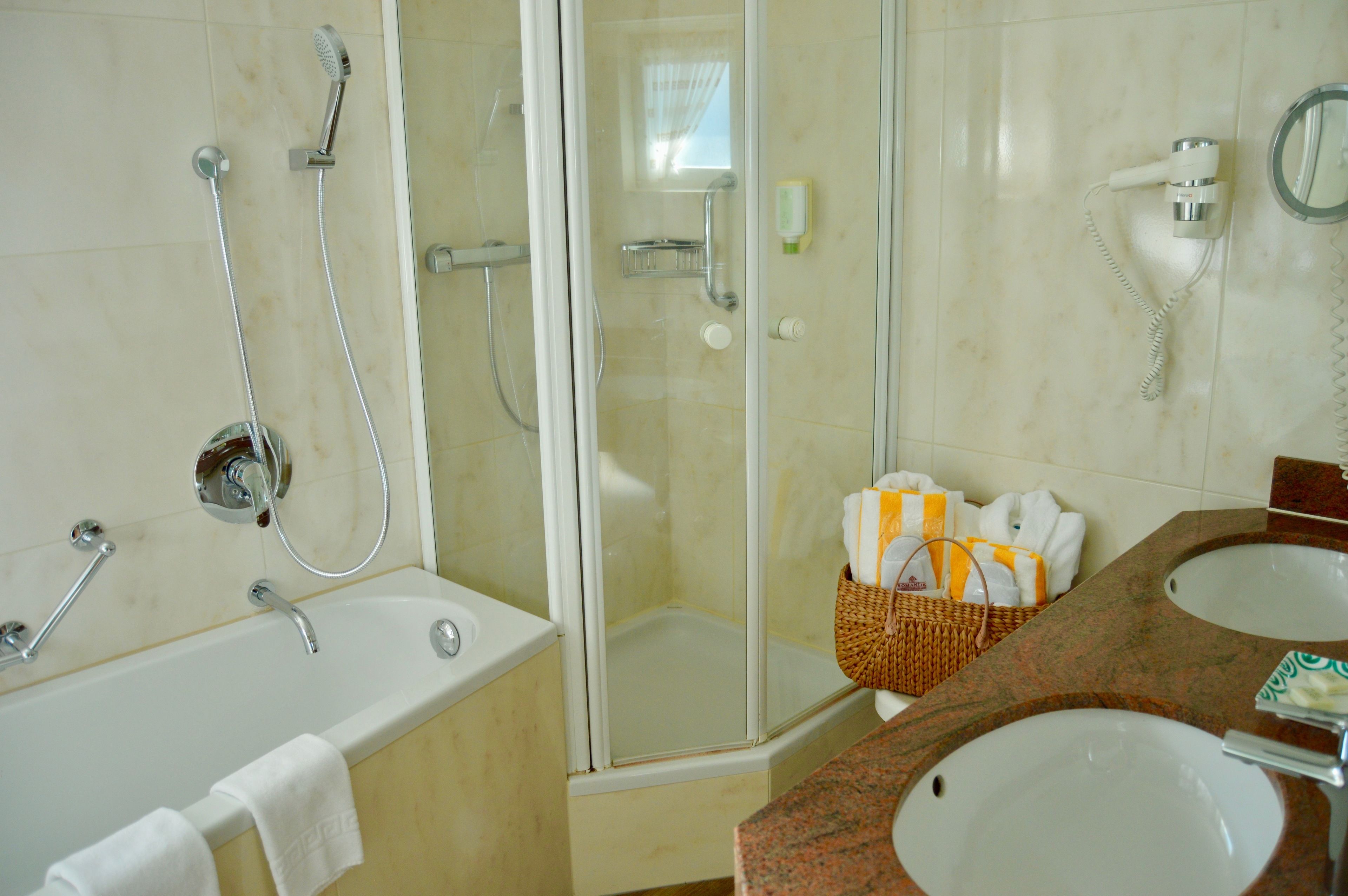 Une salle de bain avec une baignoire, une douche et un lavabo.