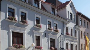 Un hotel a più piani con facciate bianche, numerose finestre e balconi fioriti.