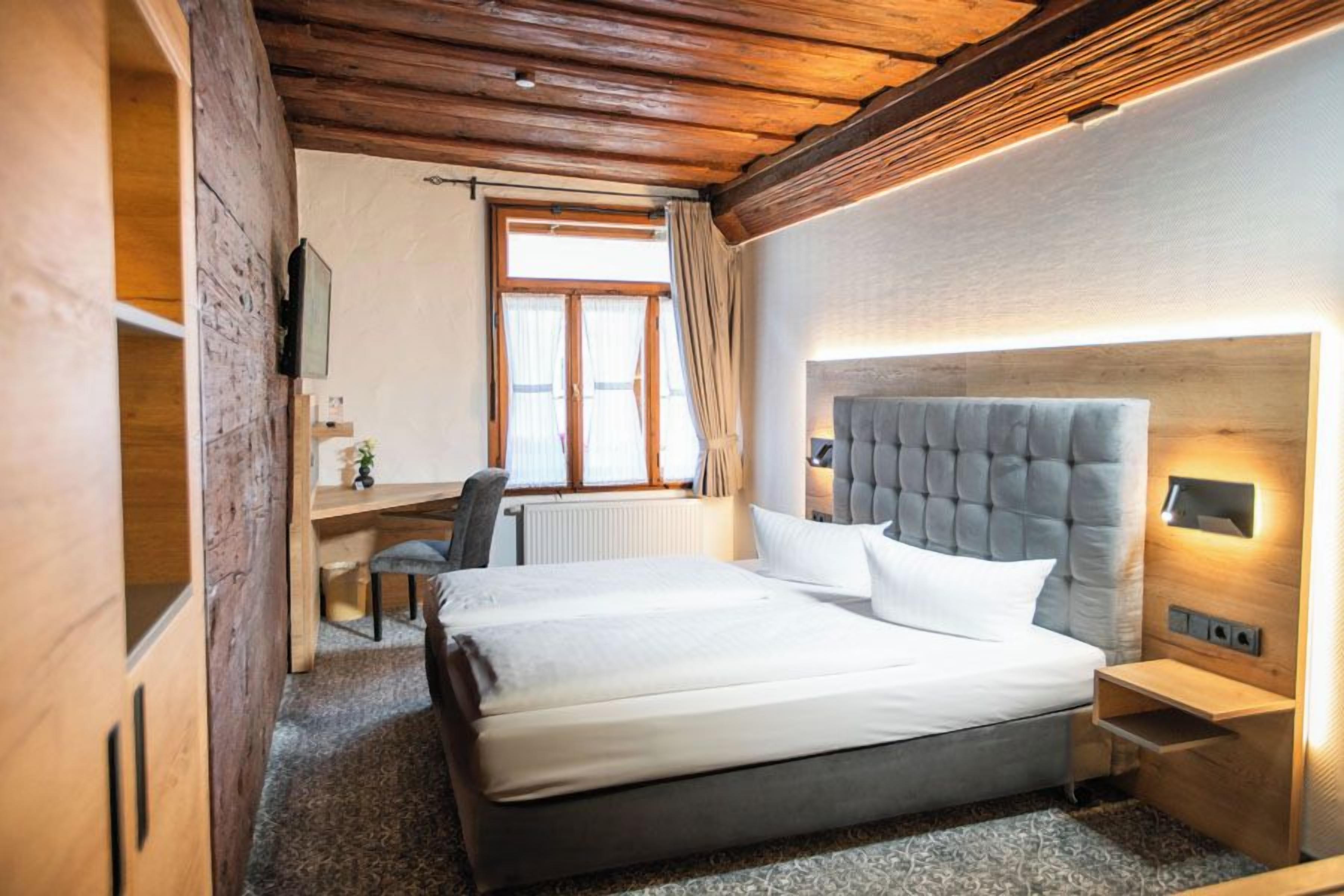 Un dormitorio con una cama grande, un escritorio y una silla.