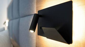 A wall-mounted light fixture with a cylindrical shade and a flat panel.