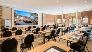 A conference room with tables and chairs, a large screen, and brick walls. - Best Western Hotel Schlossmuehle (Quedlinburg)