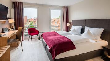 Une chambre d’hôtel avec un lit, un bureau, une chaise et un téléviseur.