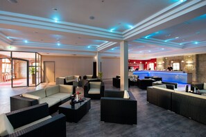 A spacious lobby with modern furniture, a reception desk, and a bar area. - Best Western Hotel Schlossmuehle (Quedlinburg)