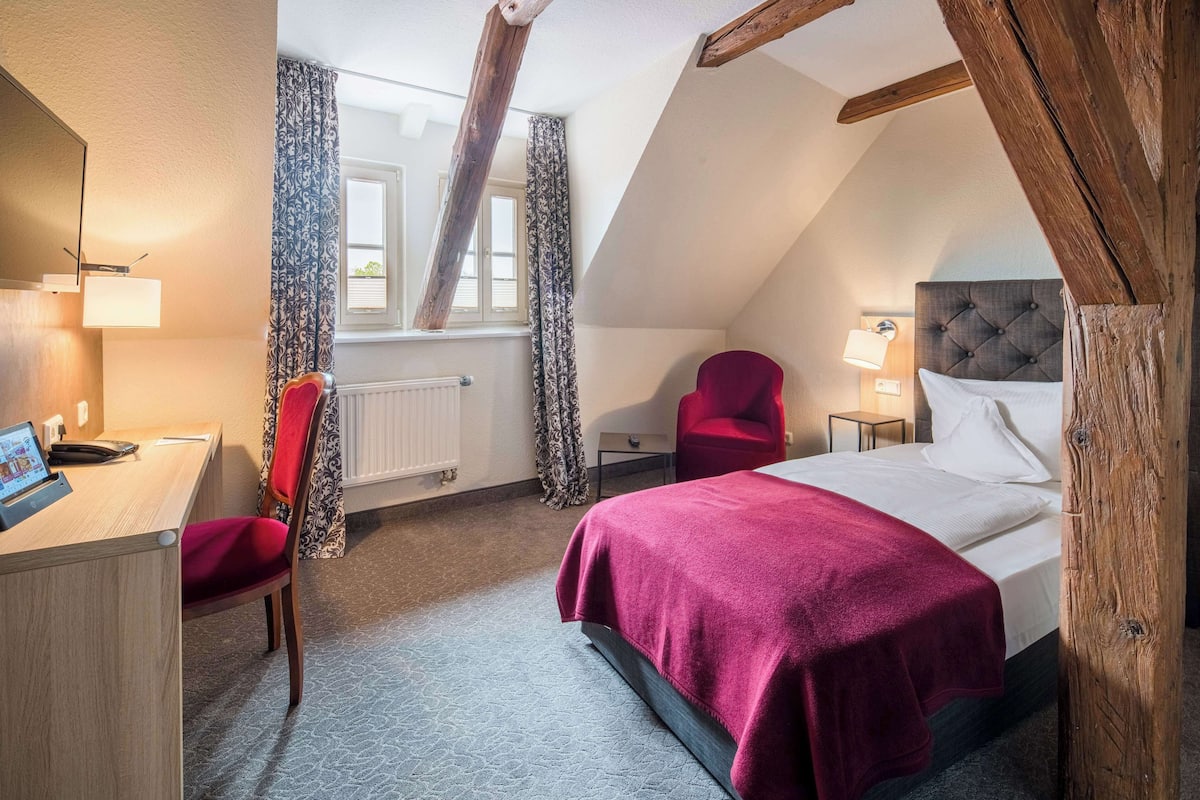 Une chambre à coucher avec un lit, un bureau et une chaise.