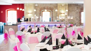 A banquet hall with round tables, black and white tablecloths, and pink chair covers. - Best Western Hotel Schlossmuehle (Quedlinburg)