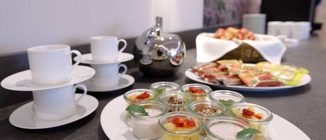 Un bufé de desayuno con diferentes alimentos y un juego de té.