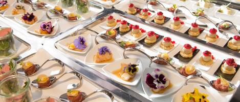 A variety of plated appetizers arranged on a buffet table.
