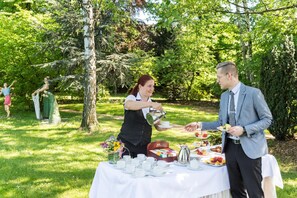 Ein Garten mit einem gedecktem Tisch, umgeben von Pflanzen und Bäumen.