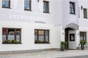 A building with the names "ANTONIUSHOF" and "TONI WIRT" on the facade, indicating it is a hotel.