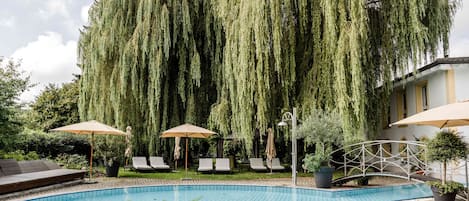 Una piscina cubierta, una piscina al aire libre de temporada, sombrillas