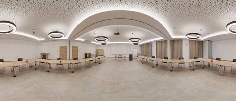A conference room with a long table, multiple chairs, and a projector screen.