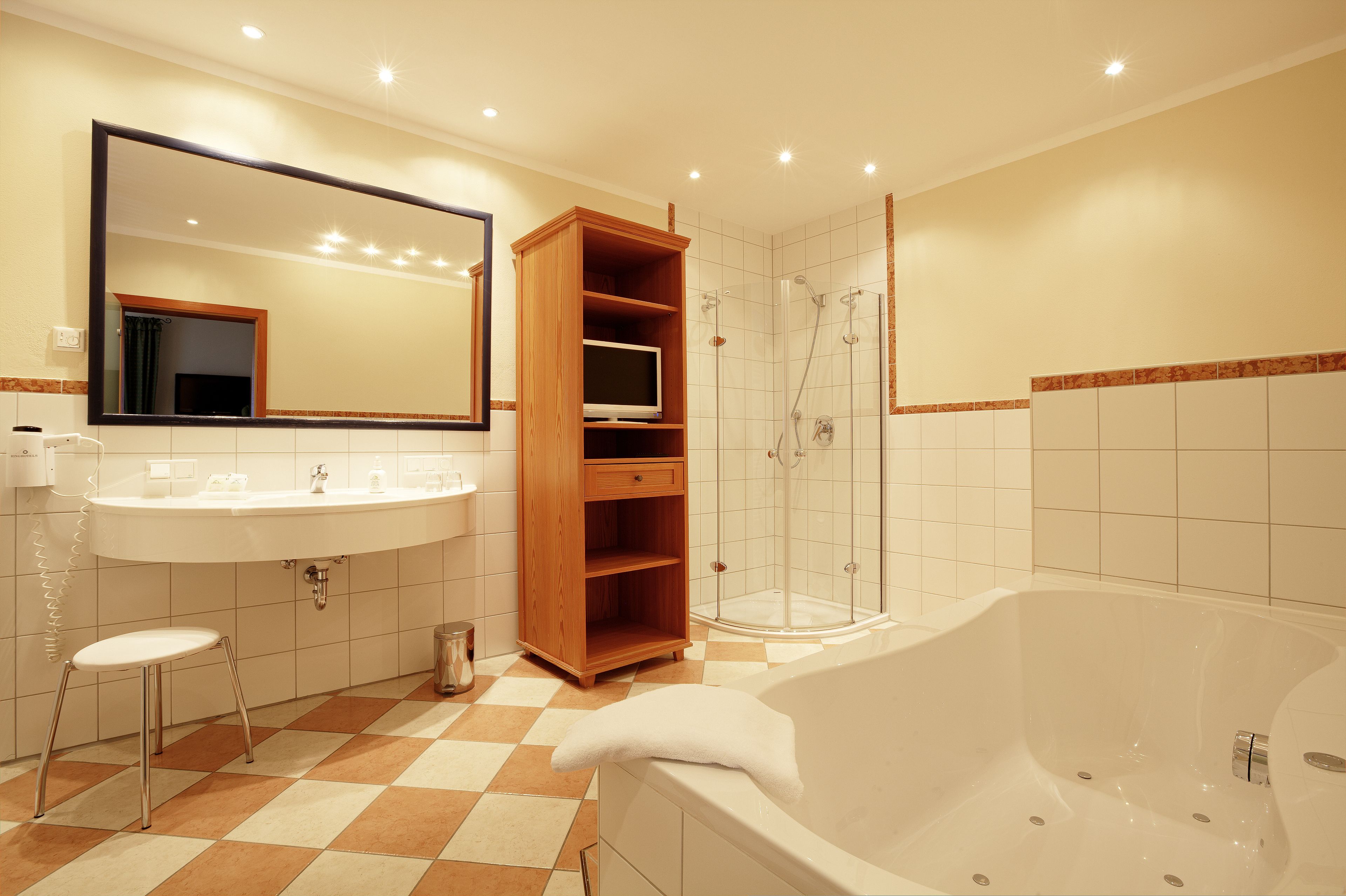 A modern bathroom with a large mirror, a sink, a toilet, a shower, and a bathtub.