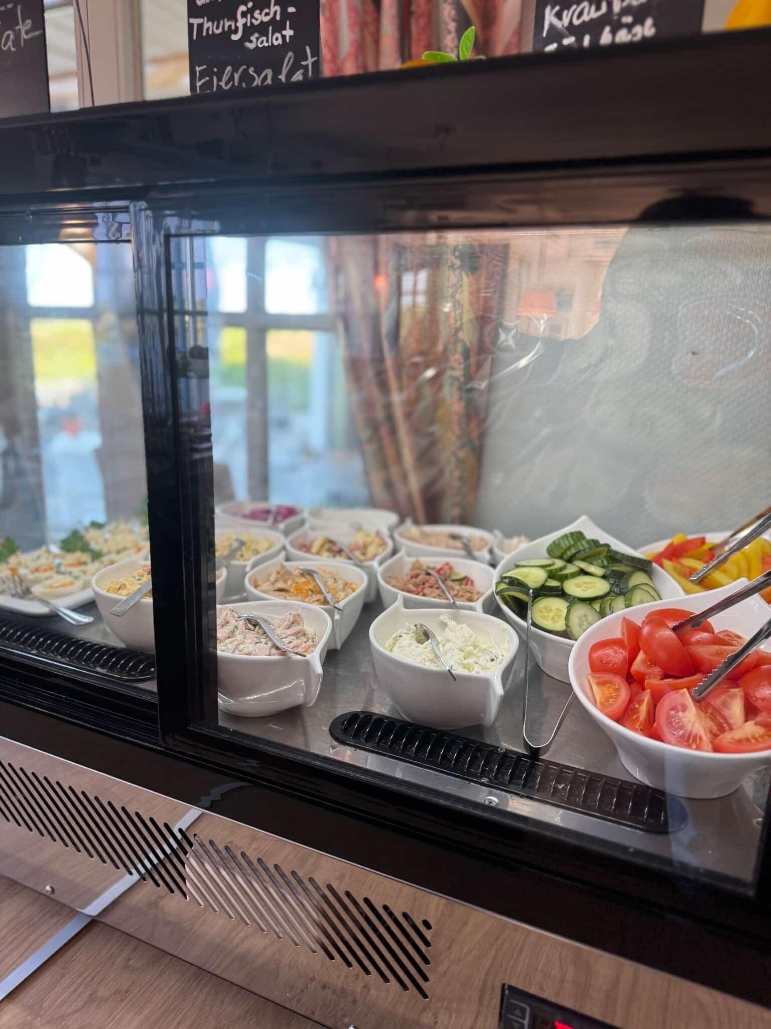 A buffet with various food options including salads, vegetables, and possibly some cold cuts.