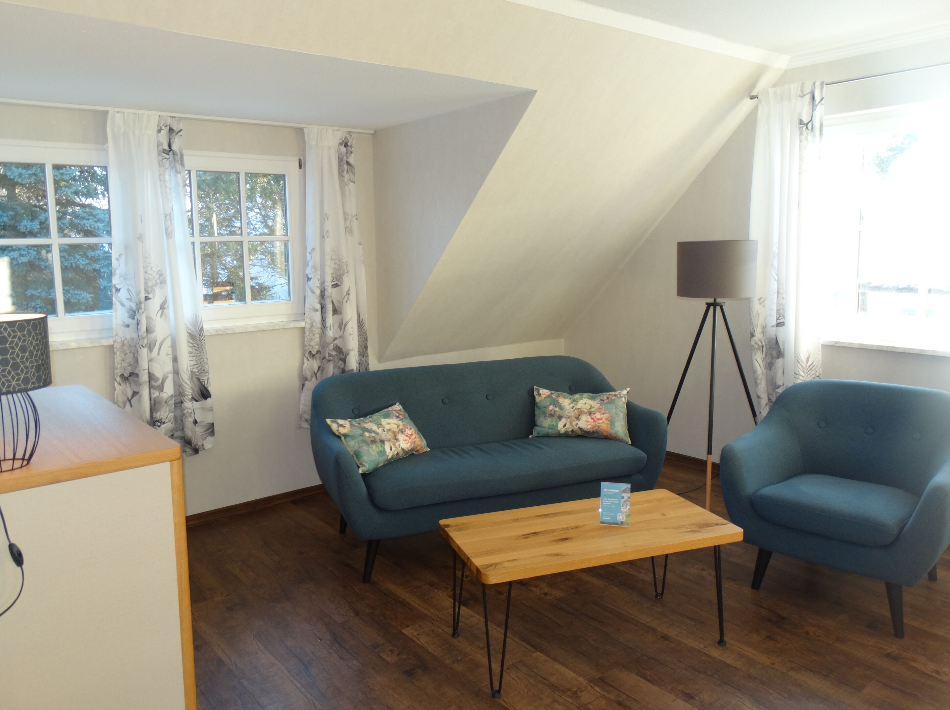 Una sala de estar acogedora con un sofá, una silla, una mesa de centro y una lámpara.