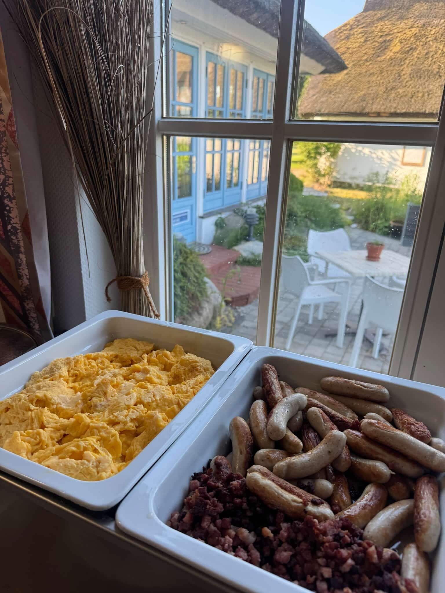 Un bufé con huevos revueltos y salchichas.