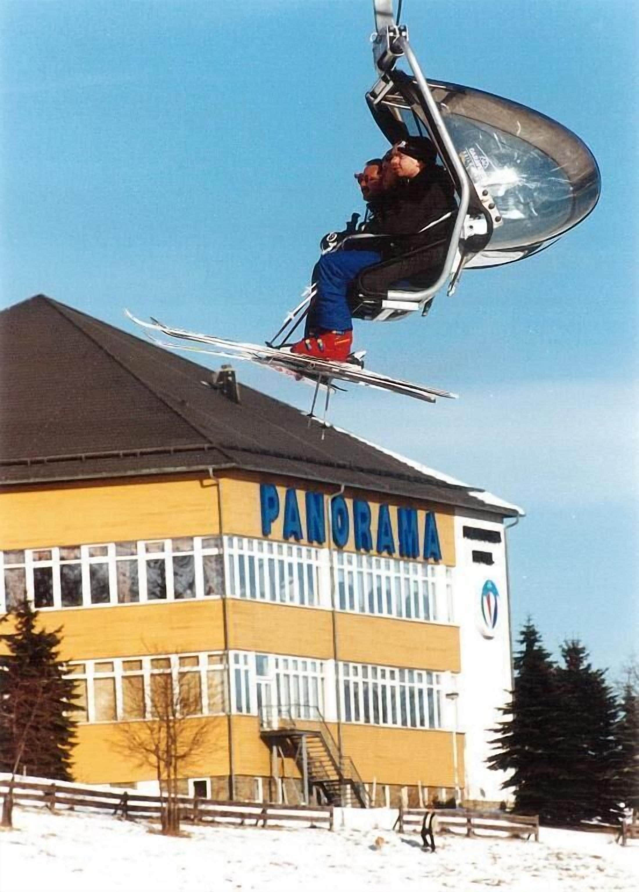 Eine Seilbahn mit einer Person in einer blauen Jacke und roten Hose.