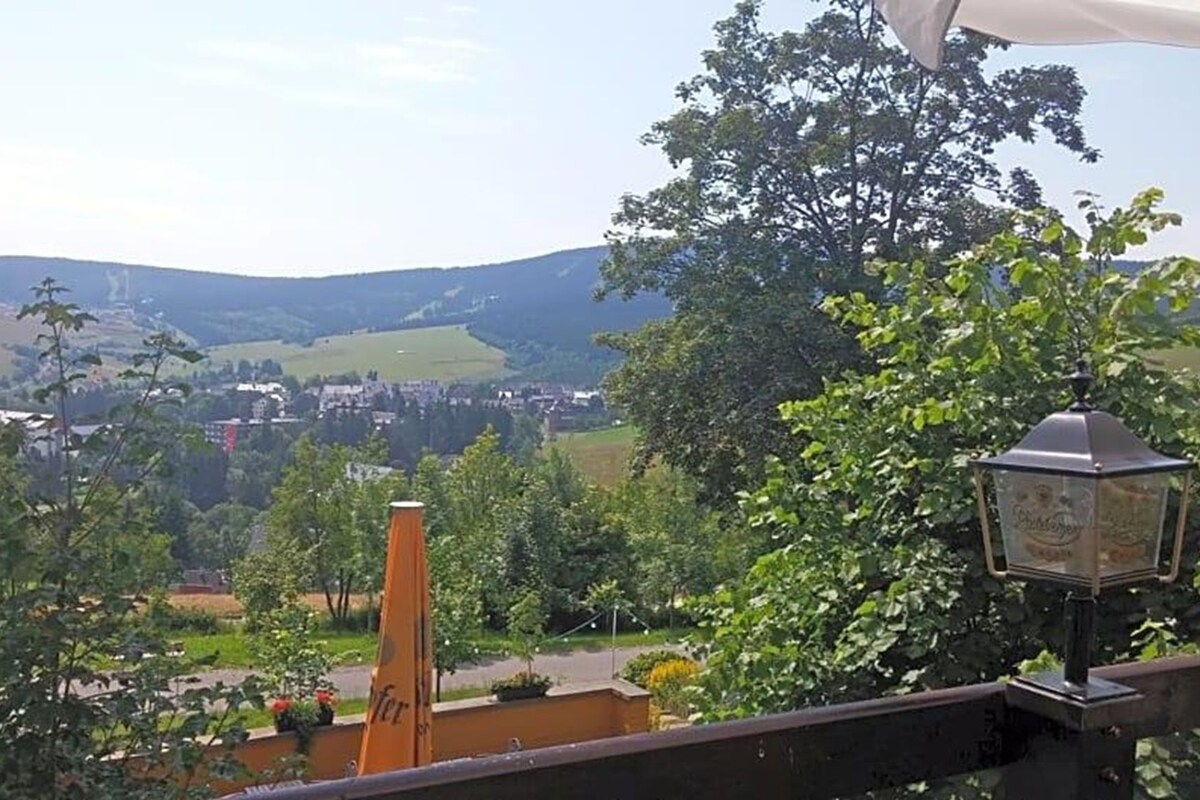 Un balcon donnant sur la ville et les collines.