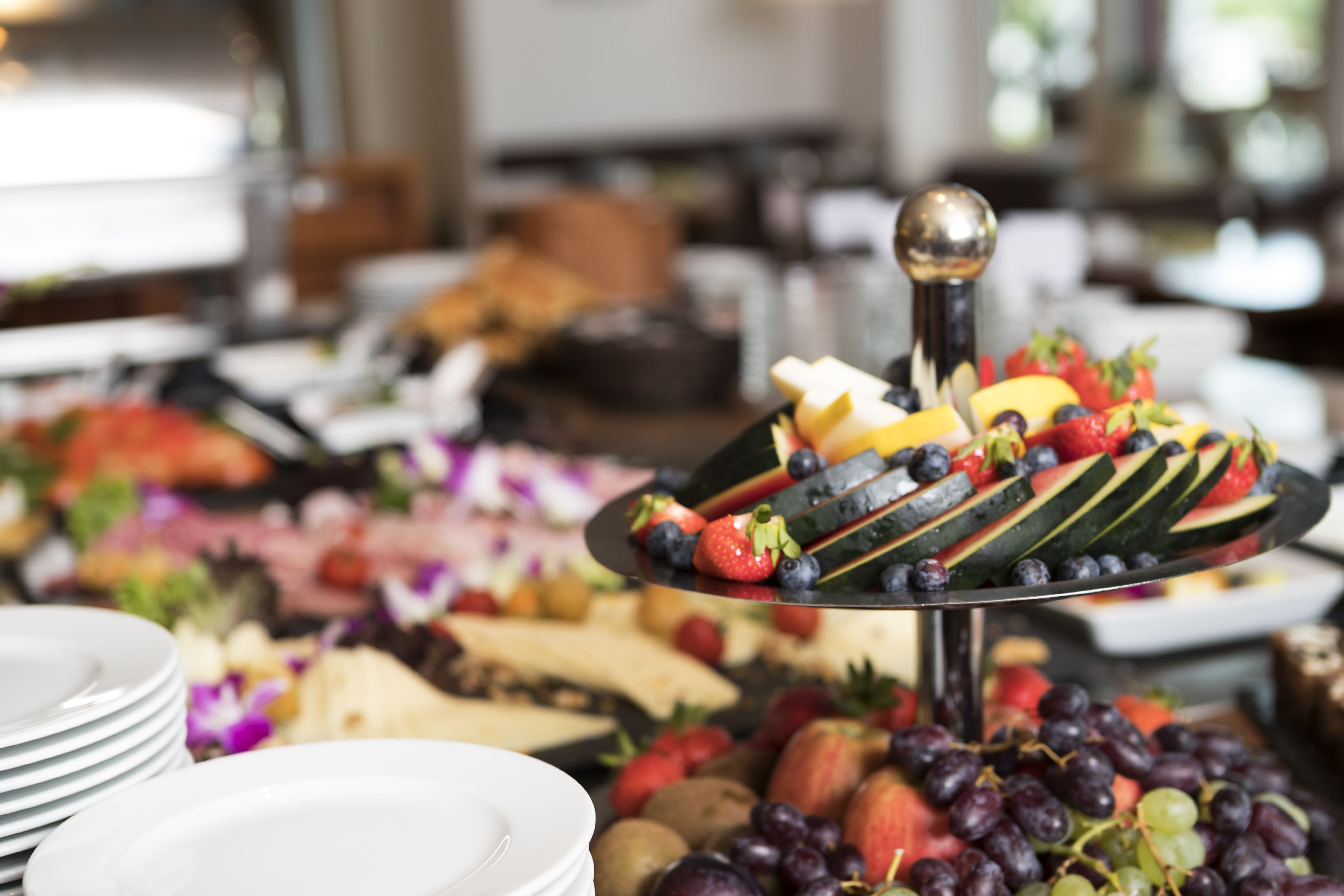 Une table de buffet avec divers fruits et fromages.