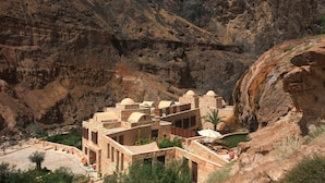A desert resort with multiple buildings, including a pool area and a view of the surrounding rocky landscape.
