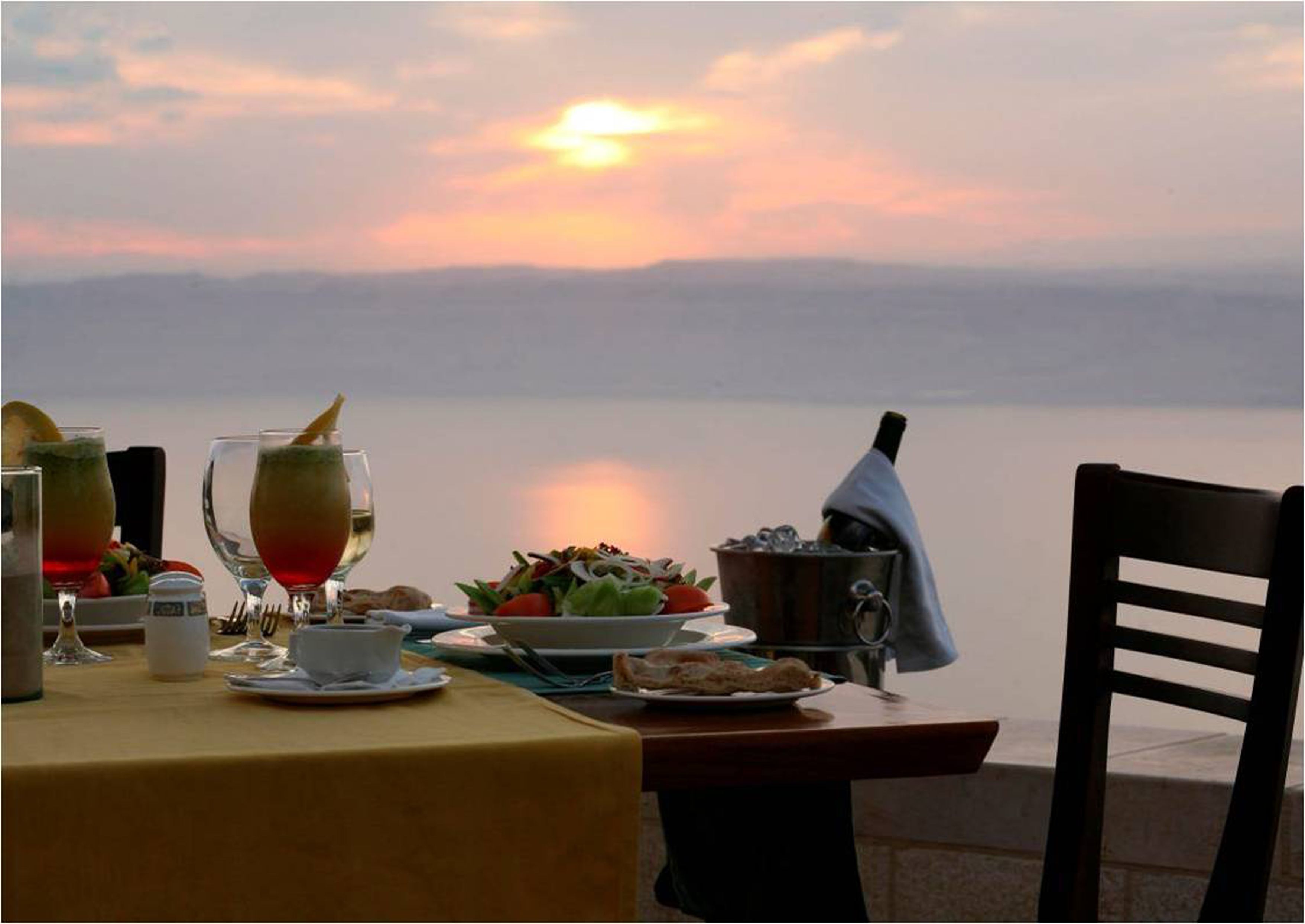 A table set for a meal with a sunset view.