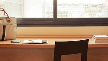Escritorio, cortinas blackout y tabla de planchar con plancha