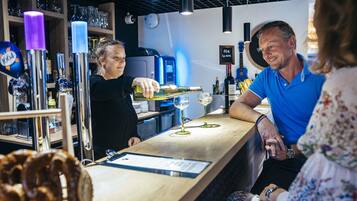 A bar area with a counter, glasses, and a menu.