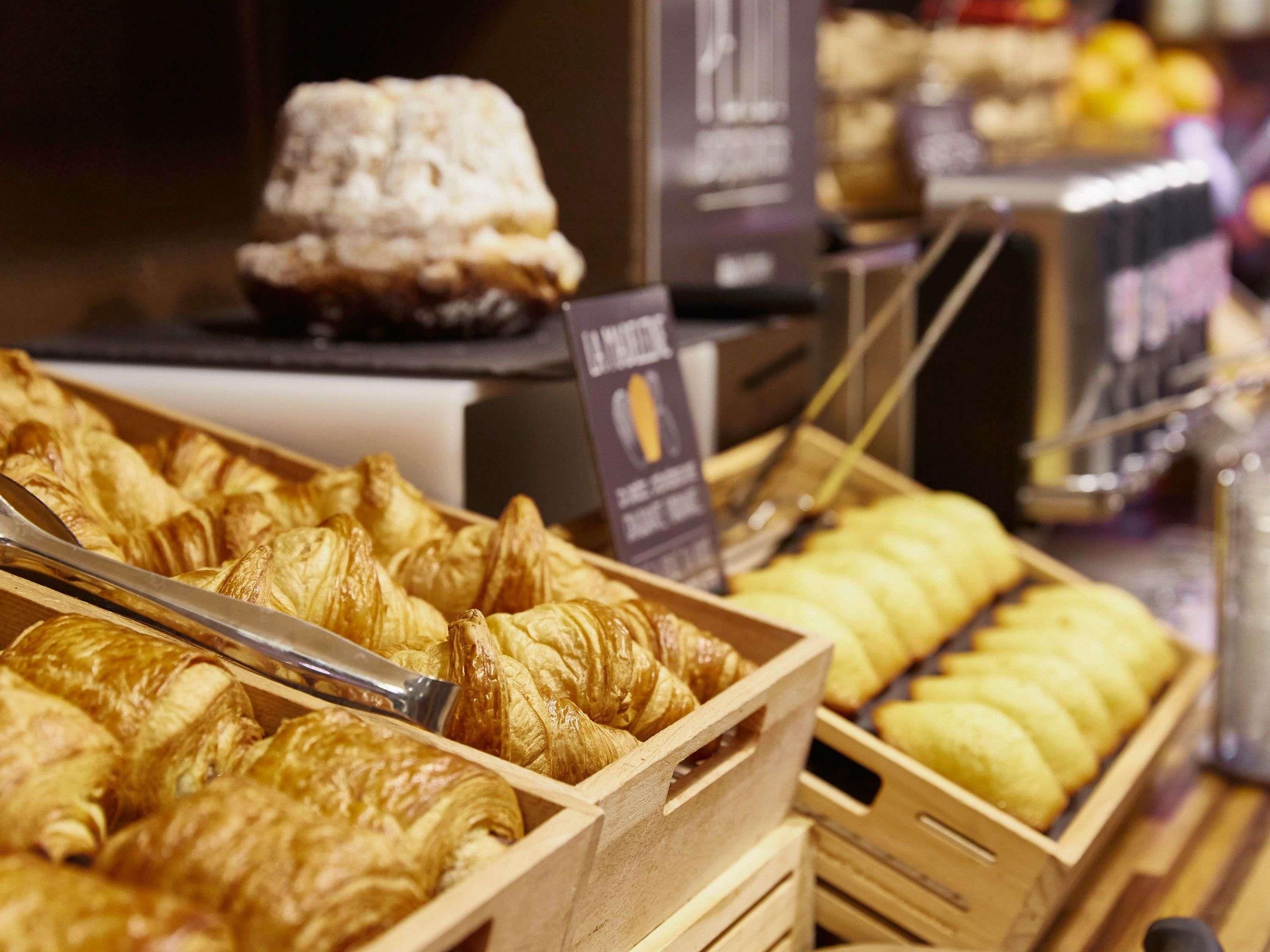 Eine Backvitrine mit verschiedenen Backwaren, darunter Croissants und eine Torte.