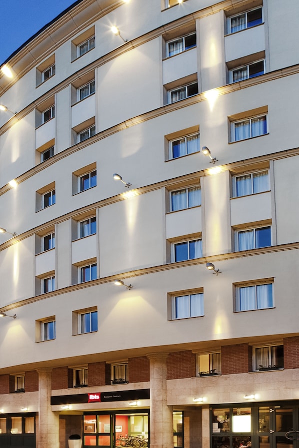 A multi-story hotel with a modern facade, featuring evenly spaced windows and a central entrance with signage.