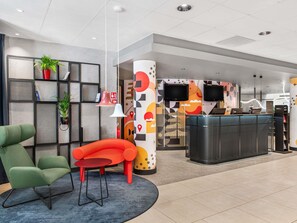 A modern reception area with a desk, chairs, and a decorative wall. - ibis Budapest Centrum (Budapest)