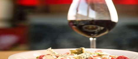 A plate of food with a glass of red wine.