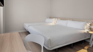 Una habitación de hotel moderna con una cama grande, una mesita y una silla.