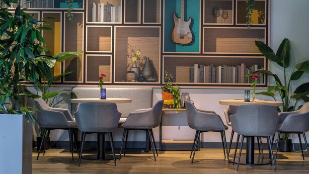 Um interior moderno com área de estar, estantes e plantas decorativas.