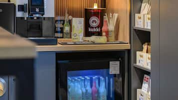 A bar area with a jukebox, a refrigerator stocked with bottles, and a sign indicating 'COCKTAILS' and 'KUKKI'.