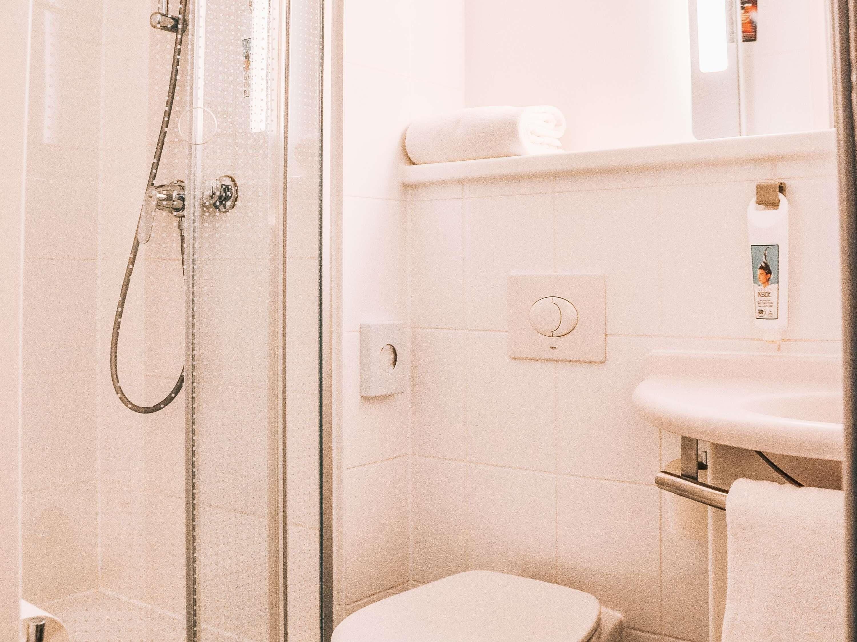 Ein Badezimmer mit Dusche, Toilette und Waschbecken.