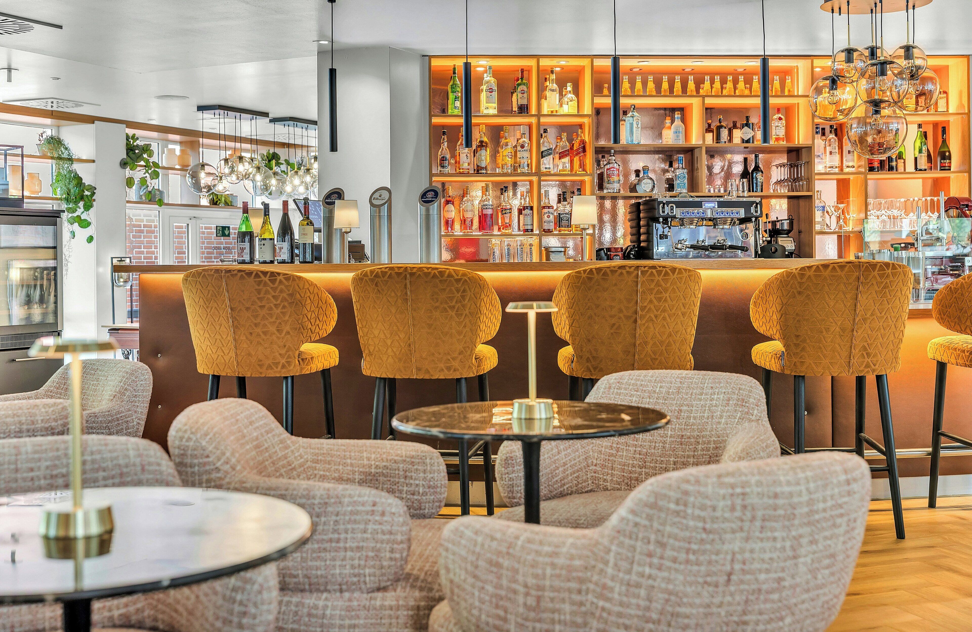 A bar area with seating, a bar counter, and shelves of bottles.