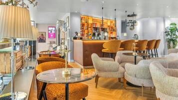 Zona moderna de bar con barra, taburetes y una variedad de botellas.