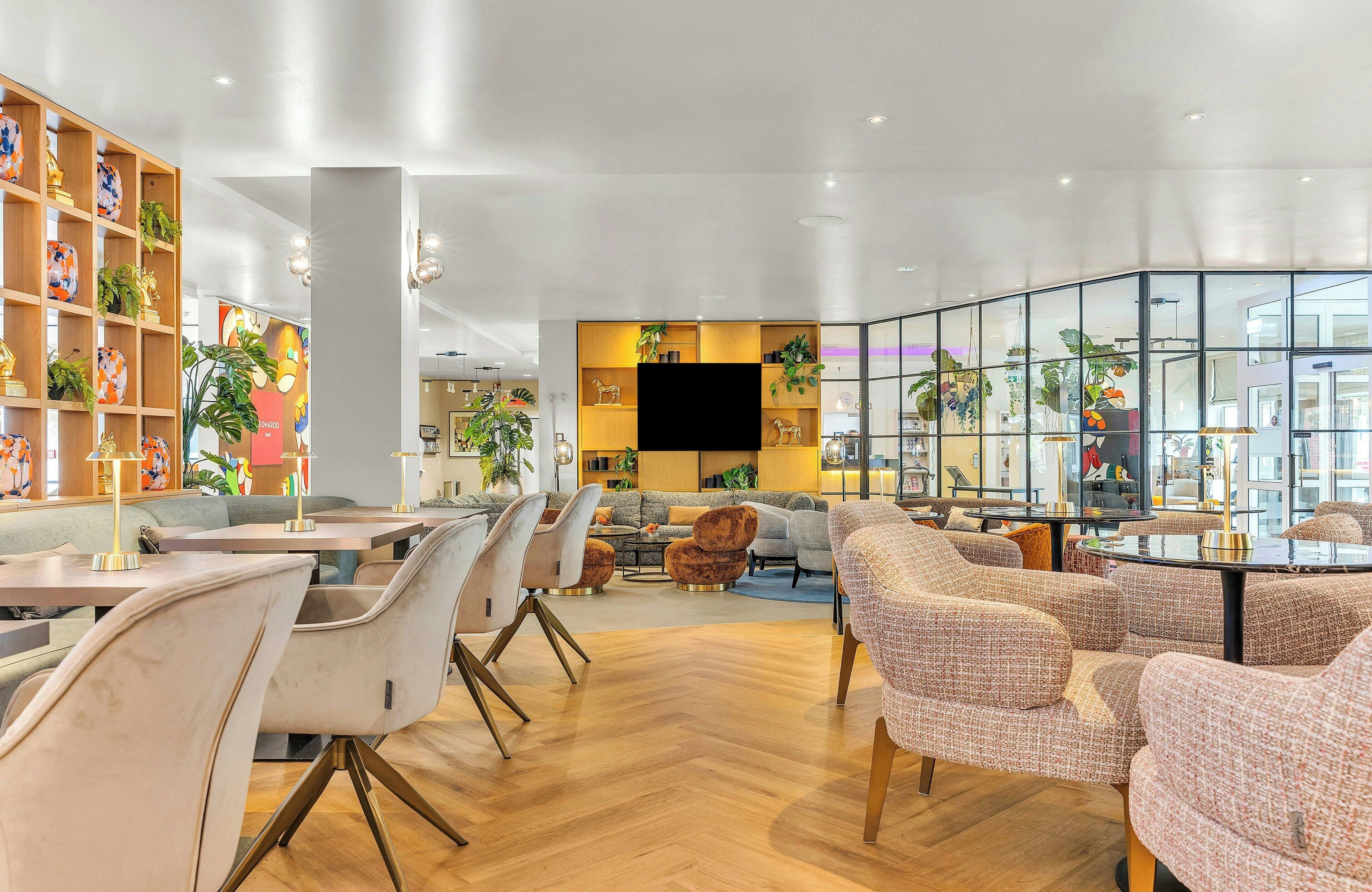Ein modernes Interieur mit einer Sitzecke, Holzregalen mit Dekoration und einem großen Fenster.