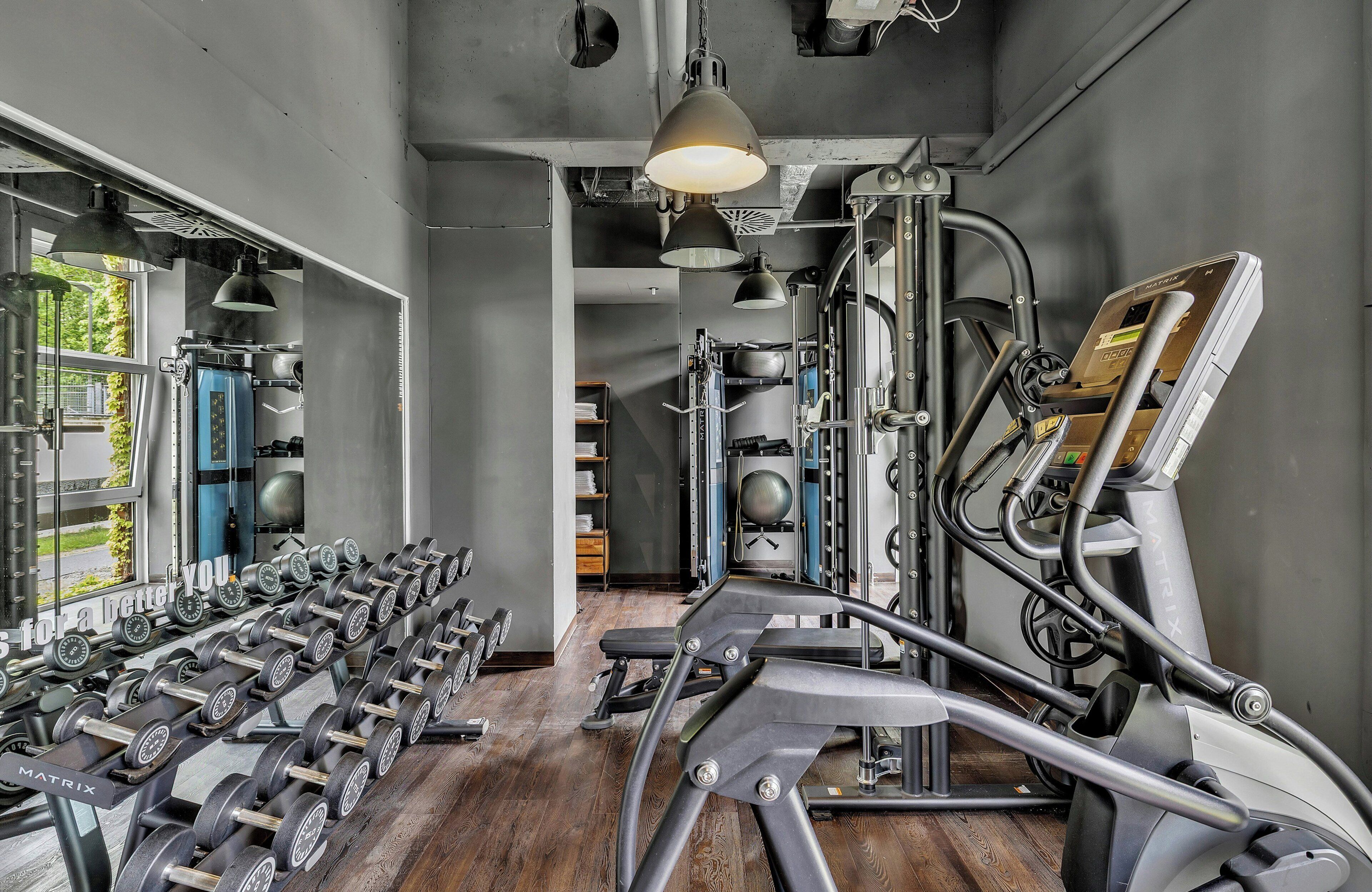 A gym with exercise equipment, a treadmill, and a mirror.