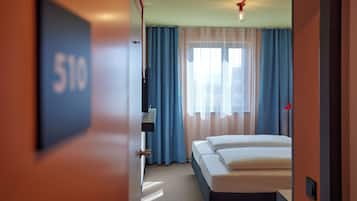 Habitación de hotel con una cama, televisor y un cartel que indica el número 510.