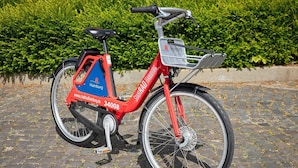 A red electric bike with a basket and a website URL on the frame. - ibis Hamburg Alsterring (Hamburg)