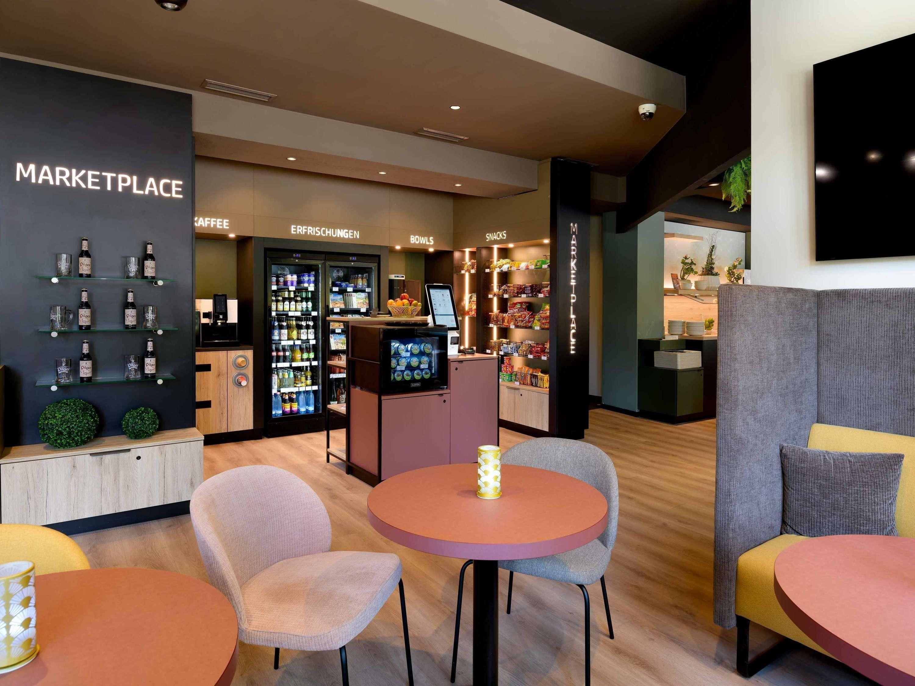 Een modern interieur met een kitchenette, een koffiehoek en zitplaatsen.