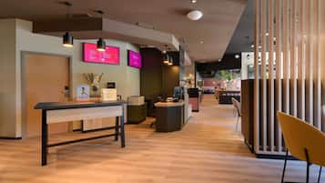 A modern reception area with a wooden desk, a key box, and a reception counter.