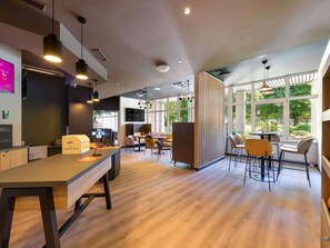 Un interior moderno con mostrador de recepción, zona de estar y ventanas amplias.