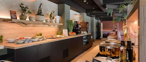 A modern kitchen area with a buffet setup, including various food items and condiments.